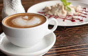 Obraz na płótnie Canvas a white ceramic cup of cappucino as a coffee break concept