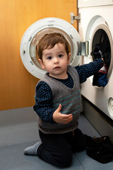Child helping to set up the washing machine to do the laundry.