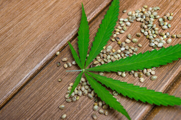 Cannabis Marijuana fresh leaves and seeds on wooden background. Vegetarian food concept. Natural cannabis product concept.