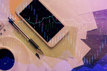 Multi exposure of forex graph hologram over desktop with phone. Top view. Mobile trade platform...