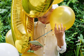 birthday boy with balloons and smartphone in hand, greetings on the phone during the pandemic - Powered by Adobe