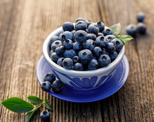 Fresh blueberries in a ceramic bowl on a wooden table