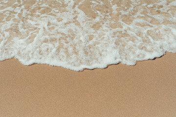 Wave reaching the beach sand wallpaper.