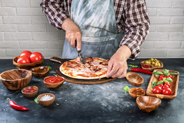 Pizza preparation with chef hands. Cutting pizza