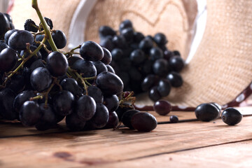 Bunches of fresh ripe red grapes on the surface with a wooden texture. Beautiful background with a...
