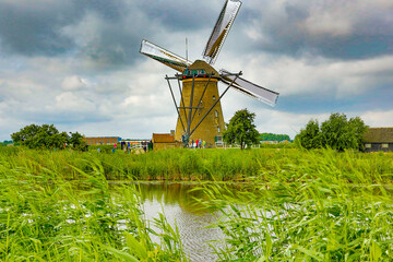 Naklejka premium Kinderdijk, Netherlands; A group of tourists visiting windmills at the Kinderdijk, the Netherlands