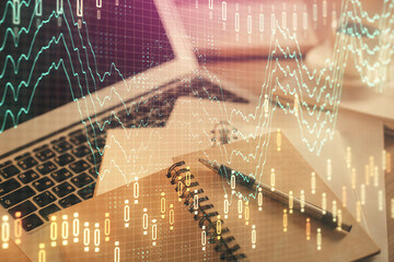 Double exposure of financial chart drawing and desktop with coffee and items on table background. Concept of forex market trading