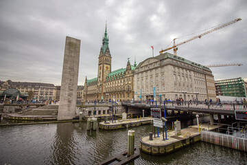 Fototapeta na wymiar Lake Binnenalster in Altstadt quarter and at the background the famous Hamburg town hall with dramatic clouds at market square Hamburg, Germany.