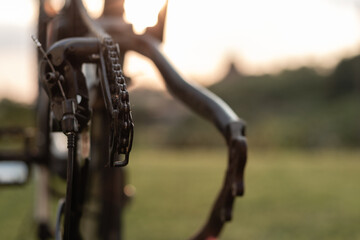 Closeup of chain on bike as its in maintenance on green field after getting flat tire. 