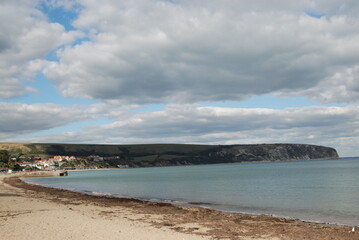 Dorset Beach in England Ocean Photo With Clear Blue Water and Blue Sky with Puffy White Clouds 