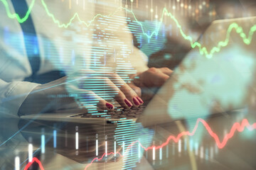 Double exposure of businesswoman hands typing on computer and financial graph hologram drawing. Stock market analysis concept.