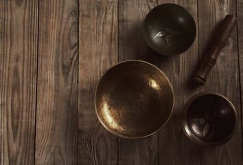 Tibetan singing copper bowl with a wooden clapper on a brown wooden table