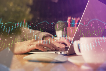 Double exposure of woman hands typing on computer and forex chart hologram drawing. Stock market invest concept.