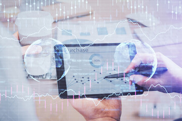 Double exposure of man's hands holding and using a phone and financial chart drawing. Market analysis concept.