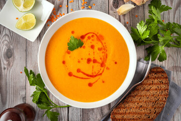 Close up of creamy winter lentil soup on gray rustic background