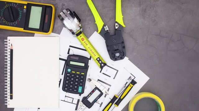 Construction tools and plans moving around open notebook. Stop motion 