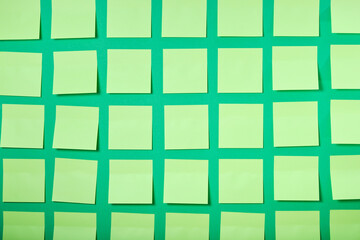 lots of light green sticky notes on green background, brainstorming and teamwork concept