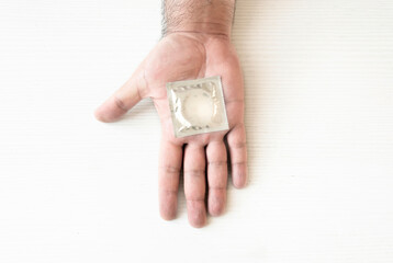 a condom packed on the palm of a male hand. Health and contraception. Prevention of sexually transmitted diseases. Safe sexnd
