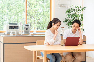 リビングでパソコンを見る夫婦・カップル