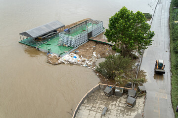 Due to the flood, mud piled up on the riverside bike paths is being cleaned up with skid loader