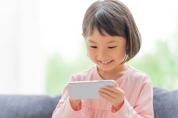 リビングでスマートフォンを使う女の子