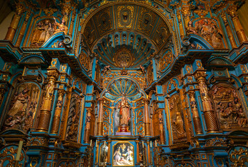 Chapel interior in the Lima Metropolitan Cathedral with Virgin Mary and baby, a baroque style altar in wood (blue and gold decorations), Lima, Peru.