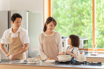 Obraz na płótnie Canvas キッチンで料理を作る女の子と両親