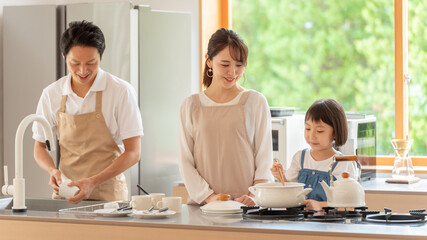 キッチンで料理を作る女の子と両親