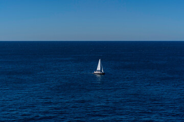 Obraz premium Seascape of the beautiful blue ocean/ sea with a Yacht Sailing in the sea