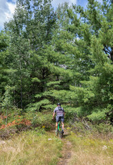 Man riding a mountain bike through the forest at Torrance Barrens in Muskoka