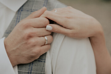 hand of the bride on the courageous shoulder of the groom. Close-up of bride's hand holding groom's shoulder. ring on the finger. 