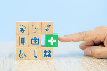 Hand choose medical icon on cube wooden toy blocks stack in with other medical symbols concepts of...