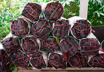 Bags of charcoal stacked in layers.