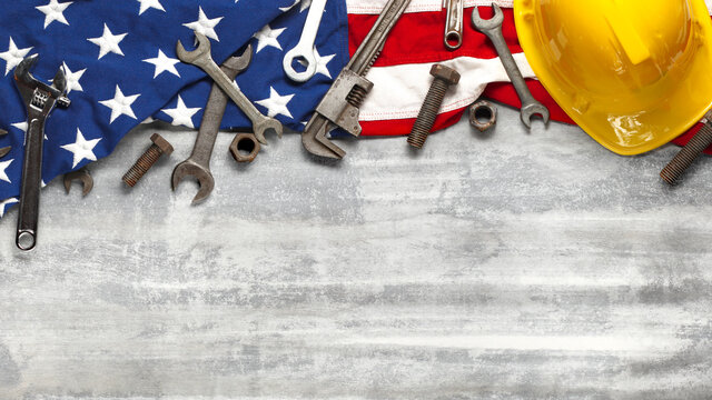 Labor day or American labor concept with construction and manufacturing tools on patriotic US, USA, American flag on white wooden background