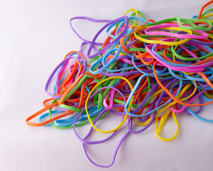 Neon multi color rainbow rubber bands on white background with copy space