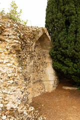 Medieval archway remains in flint stone ruin wall