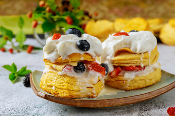 Layered flaky biscuit with berry and whipped cream.