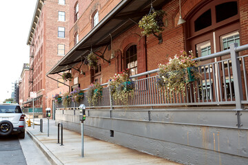 Fototapeta na wymiar Brick facade of building with flower pots on railing in Downtown Denver. Denver, Colorado, USA