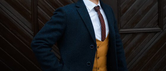 Man in a suit and coat on a background of wooden gates. Businessman