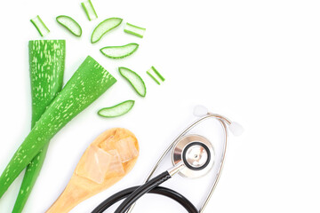 Green fresh aloe vera leaf with aloe gel and medical stethoscope isolated on white background. Top view.
