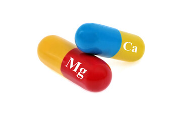 Gélules de calcium et de magnésium en gros plan sur fond blanc.