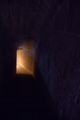Mystery. View of a dark stone underground tunnel leading to the light at the end of the corridor.  