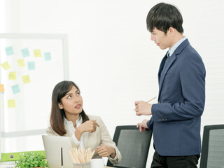 Asian business people having a casual discussion. Staff standing and discussing work in office.