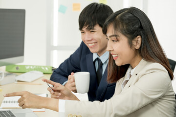 Asian staff holding credit card and using laptop computer in office. Online Shopping, internet banking, spending money