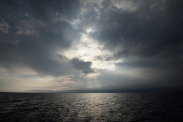 North sea after a thunderstorm, Norway. Dramatic sunset sky with glowing cumulus clouds. Epic cloudscape. A view from the sailing boat. Meteorology, cyclone, climate change, seasons