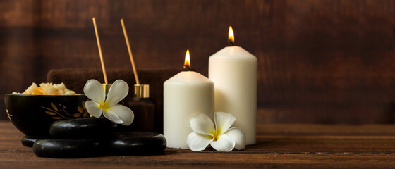 Thai spa composition treatments aroma therapy with candles and Plumeria flowers on wooden table. Healthy and Relax Concept