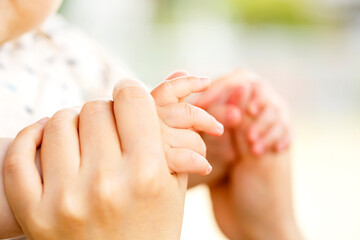 母親と赤ちゃんが手をつなぐ　両手をつなぐ親子の触れ合い