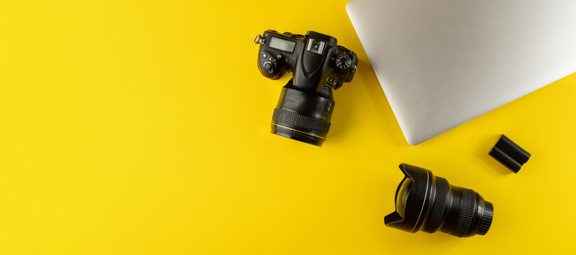 Photographer's equipment.Flat lay composition with photographer's equipment and laptop on yellow background