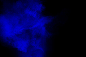 Abstract blue  powder explosion cloud  on dark background.