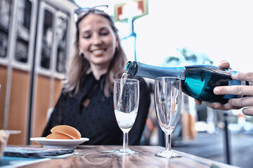 glasses of toast chin chin, hands with glasses of white wine in a street cafe